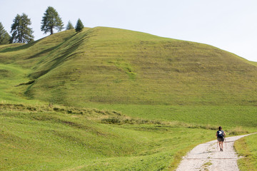 August 28, 2019: hiker walks along a green mountain path in summer