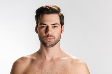 Photo of young half-naked man posing and looking at camera