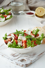 Seafood salad with squid, shrimp, cucumbers, tomatoes and lettuce. LCHF, FODMAP, paleo diet. Fresh spring vitamin mix.