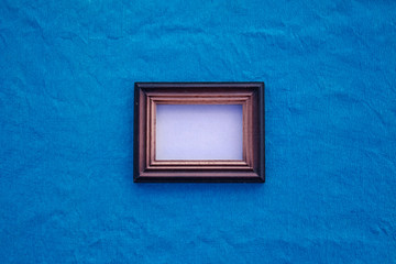 old wooden frame with a white middle on a blue background