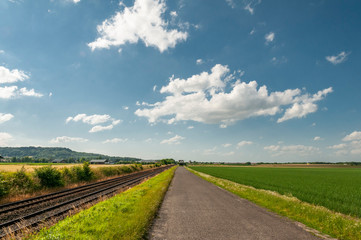 France.  Aisne. route de campagne le long d'une voie  de chemin de fer. country road along a railway track.