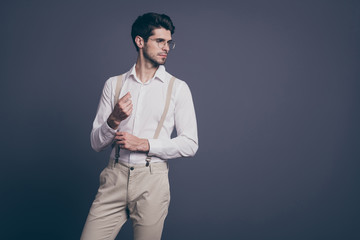 Portrait of his he nice attractive imposing elegant luxurious focused brunette man macho fixing button looking aside posing isolated on grey pastel color background