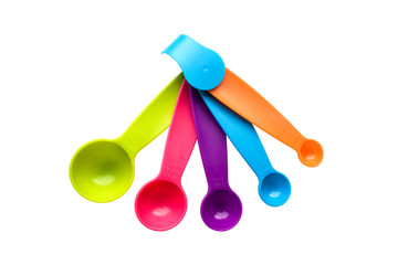 bright yellow multicolored plastic measuring spoons isolated on white background