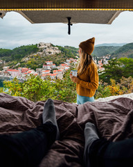 Woman and man in Camper Van enjoying the landscape view during their roadtrip.