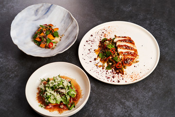 Set of various plates of food on a gray table background with copy space