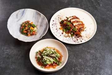 Set of various plates of food on a gray table background with copy space