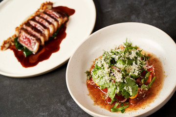 Set of various plates of food on a gray table background with copy space