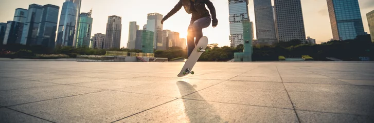Schilderijen op glas Skateboarder skateboarding at sunset city © lzf
