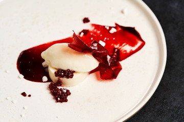 Raspberry Sorbet on a white plate, close-up. Raspberry ice cream with sweet syrup
