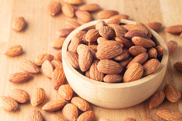 Almond seeds in a bowl wood on table wooden brown.