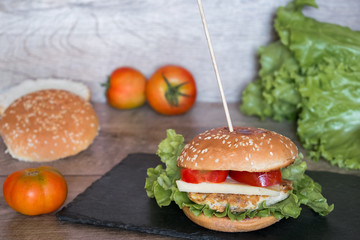 Perfect burger with fresh vegetables on black desk.