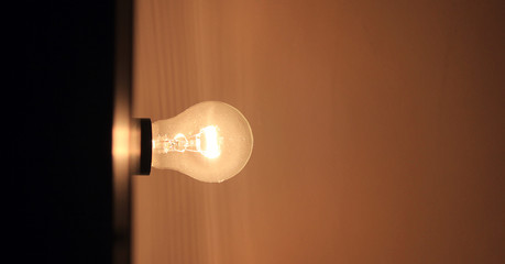 Light bulb close up view. Simple lamp against empty ceiling, lit light bulb view of illuminating...