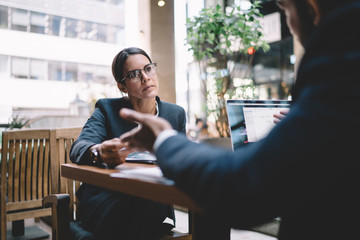 Careful businesswoman listening to colleague at workplace - Powered by Adobe