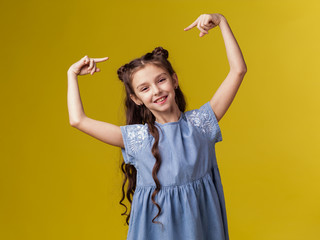 Girl child schoolgirl 7 years old with long hair points to her head brunette caucasian. Positive smile joy childhood. Care curls hairstylist hairdresser. Knowledge smart baby 
