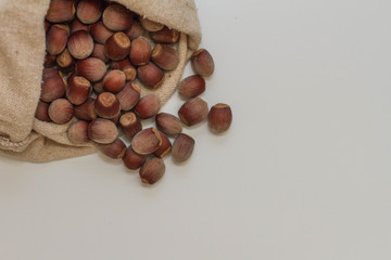 hazelnuts lie on a white background. lots of nuts in the bag. the concept of proper nutrition and health, vitamins. the view from the top, place for your text. healthy food.