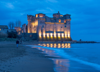 Santa Severa (Italy) - The medieval castle and town of Santa Severa, province of Rome, on the Tirreno sea with waterfront's reef. Here during the dusk with blue hour.