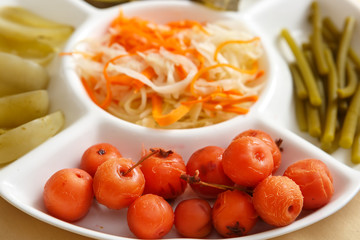 Cabbage, soaked cherries, garlic stalks green tomatoes on a plate