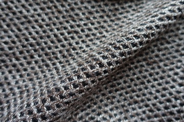 Diagonal fold on greyish brown woolen fabric