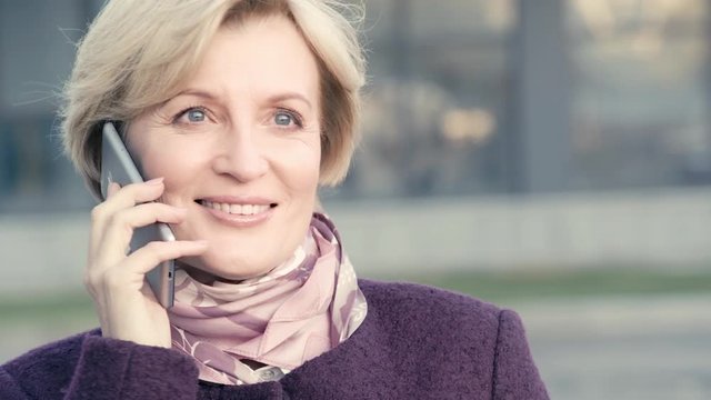 happy mature woman talking on smartphone 