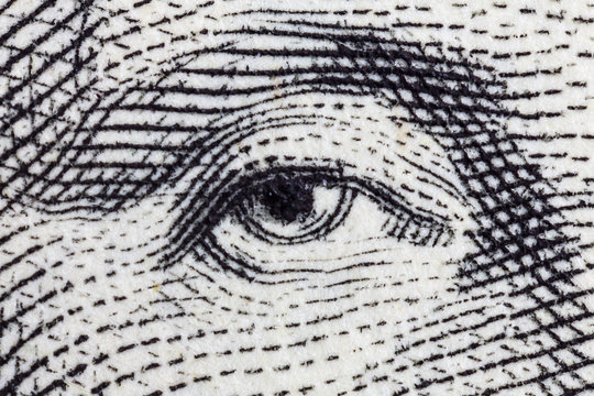 Macro close up photograph of George Washington eye on the US one dollar bill. 