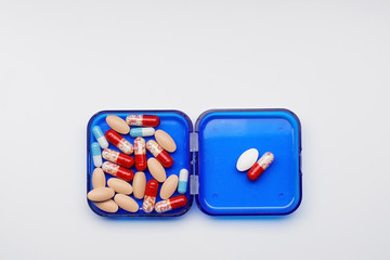 set of different capsules and tablets in a box for daily dosage. Hospital first aid kit.