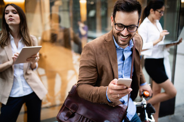 View at young business people talking and smiling outdoors