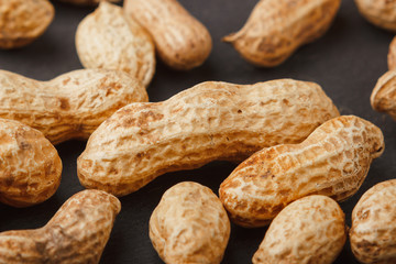 Peanuts in the shells on the black slate stone