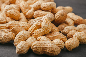 Peanuts in the shells on the black slate stone