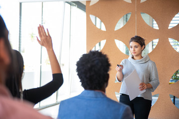 Concentrated young woman working with audience. Focused manager responding to questions. Business...