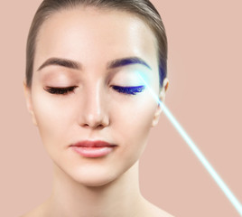 Cosmetics laser ray on beautiful female face. Laser treatment concept.