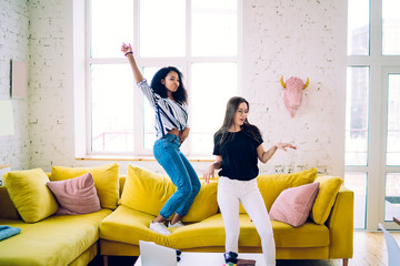 Energetic multiethnic friends dancing and having party at home