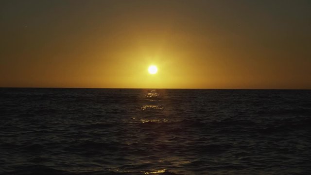 Setting sun paints the sky yellow at the sea