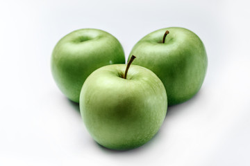 Three green apples on a white background