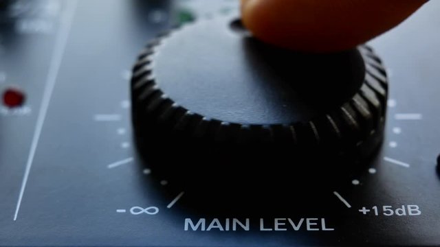 Close up volume knob turning to set levels on audio mixer. Close up 4k