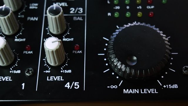 Main volume adjusting on analogue audio mixer. Close up 4k