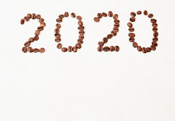 2020 made from coffee beans. Grains on a white table.