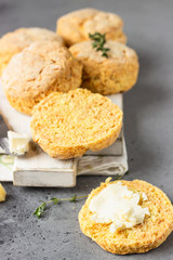 Wooden cutting board with delicious English scones with cheese. Perfect breakfast or lunch. Grey stone background.
