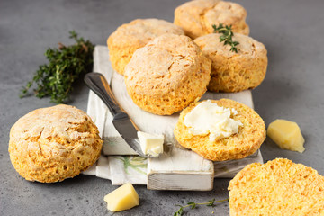 Wooden cutting board with delicious English scones with cheese. Perfect breakfast or lunch. Grey stone background.