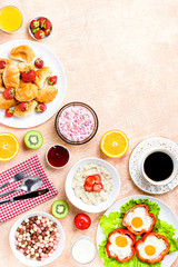 Continental breakfast with cereal, fried eggs, croissants, fruits and drinks on textured table, copy space. Table top with various healthy snacks and foods on rustic background