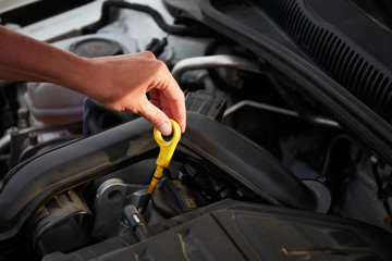 Checking engine oil. A woman's hand holding an oil bayonet in a modern popular car.