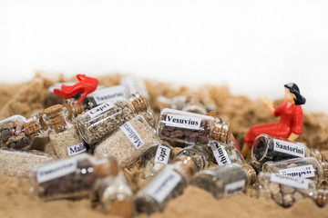 Glass test-tube with sand of different summer vacation destinations. Vacation time abstract photo.