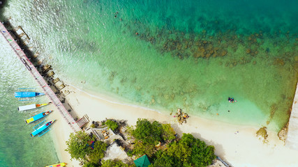 Aerial view: Tropical Island with a beautiful beach and vacationing tourists, tourist boats. Quezon...