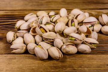 Pile of pistachio nuts on a wooden table