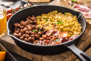 Full table of english breakfast. Scrambled eggs grilled bacon beans toast bread orange juice and coffee