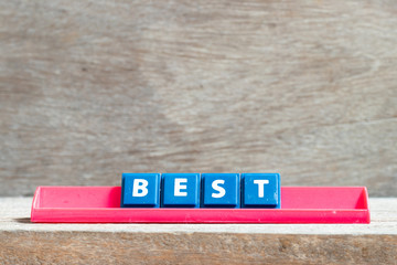 Tile letter on red rack in word best on wood background