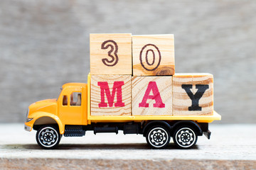 Truck hold letter block in word 30may on wood background (Concept for date 30 month May)