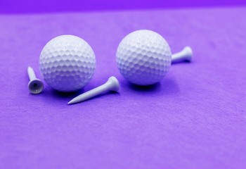 Golf ball and tees are on purple background