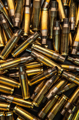 Background from empty cartridges for rifles and carbines. Shiny brass shells scattered on the...