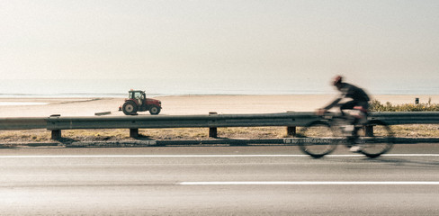 Competitive Professional Cyclist riding bicycle on Pacific Coast Highway in Santa Monica,...