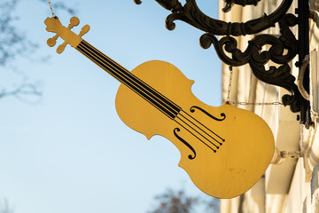 Street sign of a violin on a building